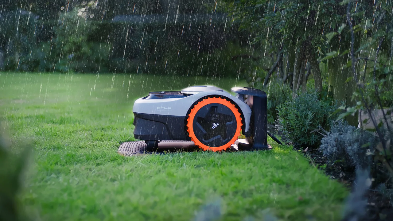 Een waterbestendige robotmaaier op een gazon met lichte regendruppels op de behuizing.