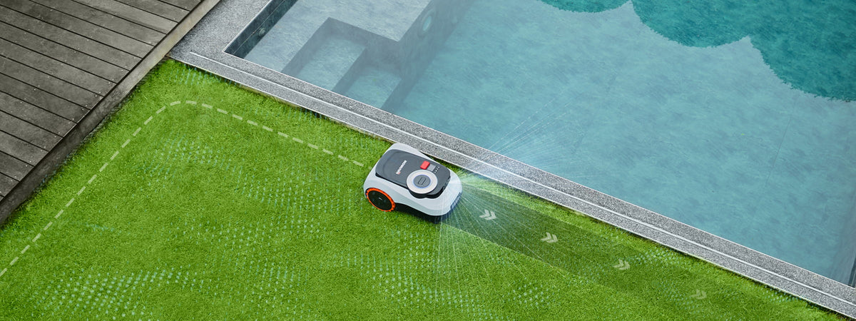 De Navimow i105E robotmaaier maait gras bij het heldere zwembad.